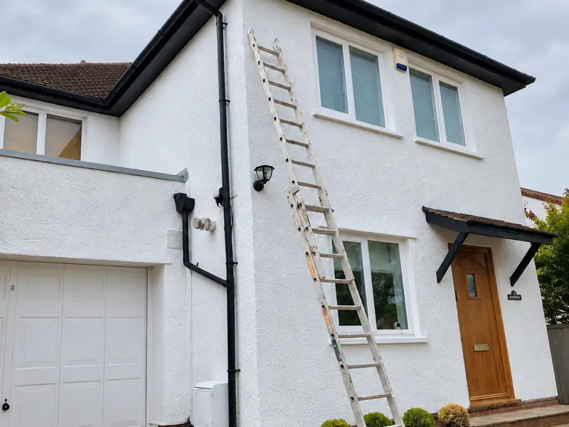 House in Cardiff with a fresh white textured render finish and black gutters
